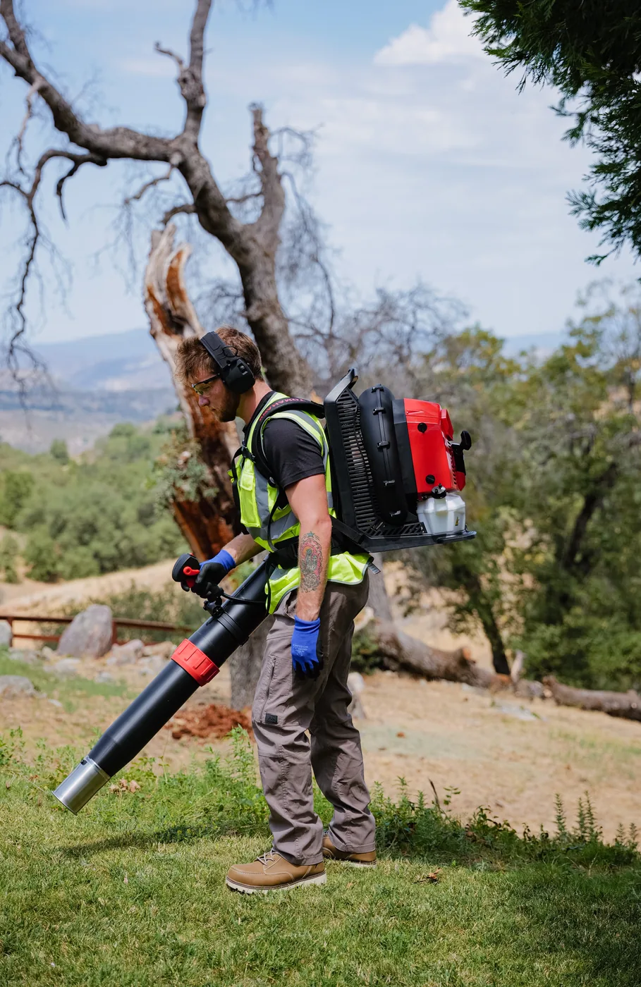 Landscaper working a dry hillside with a Tomahawk backpack blower