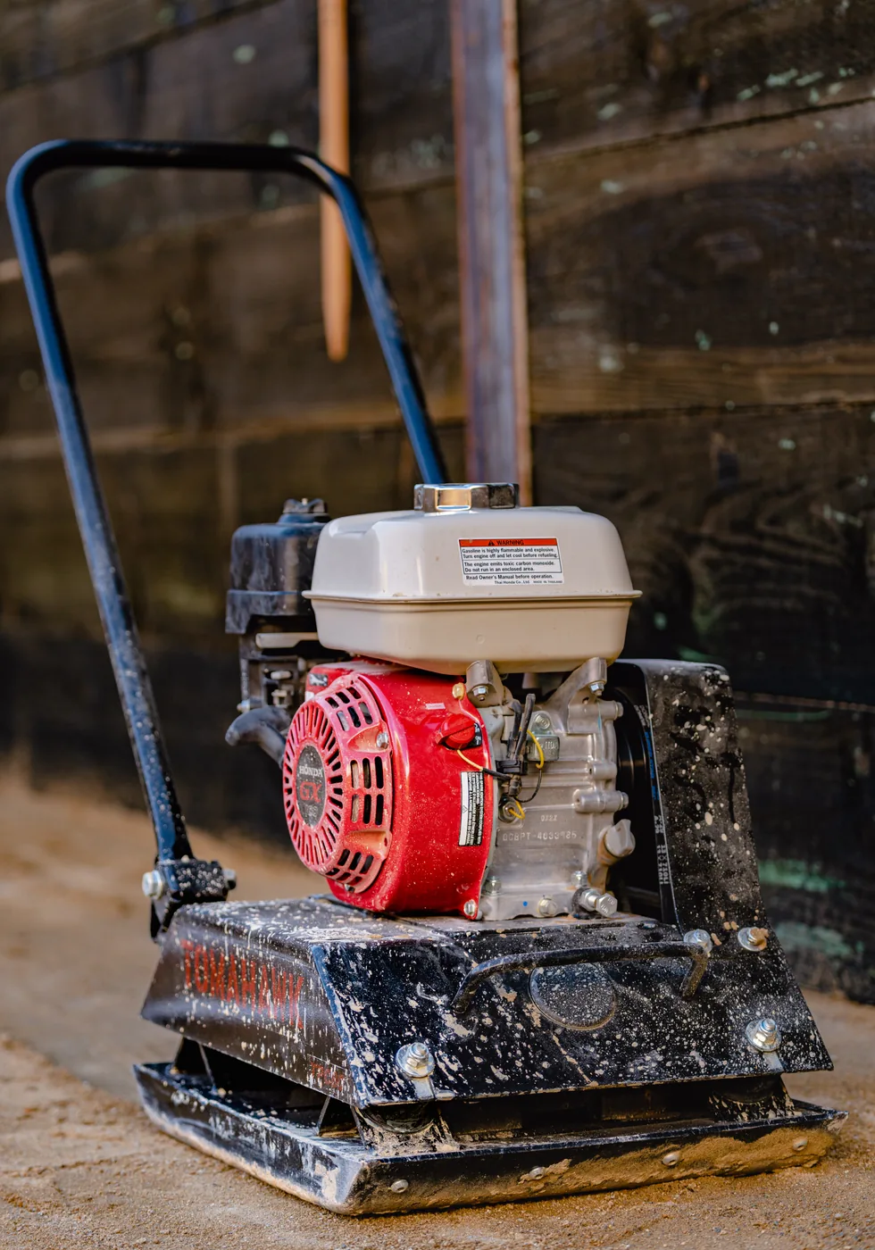 Tomahawk plate compactor parked on a dirt job site