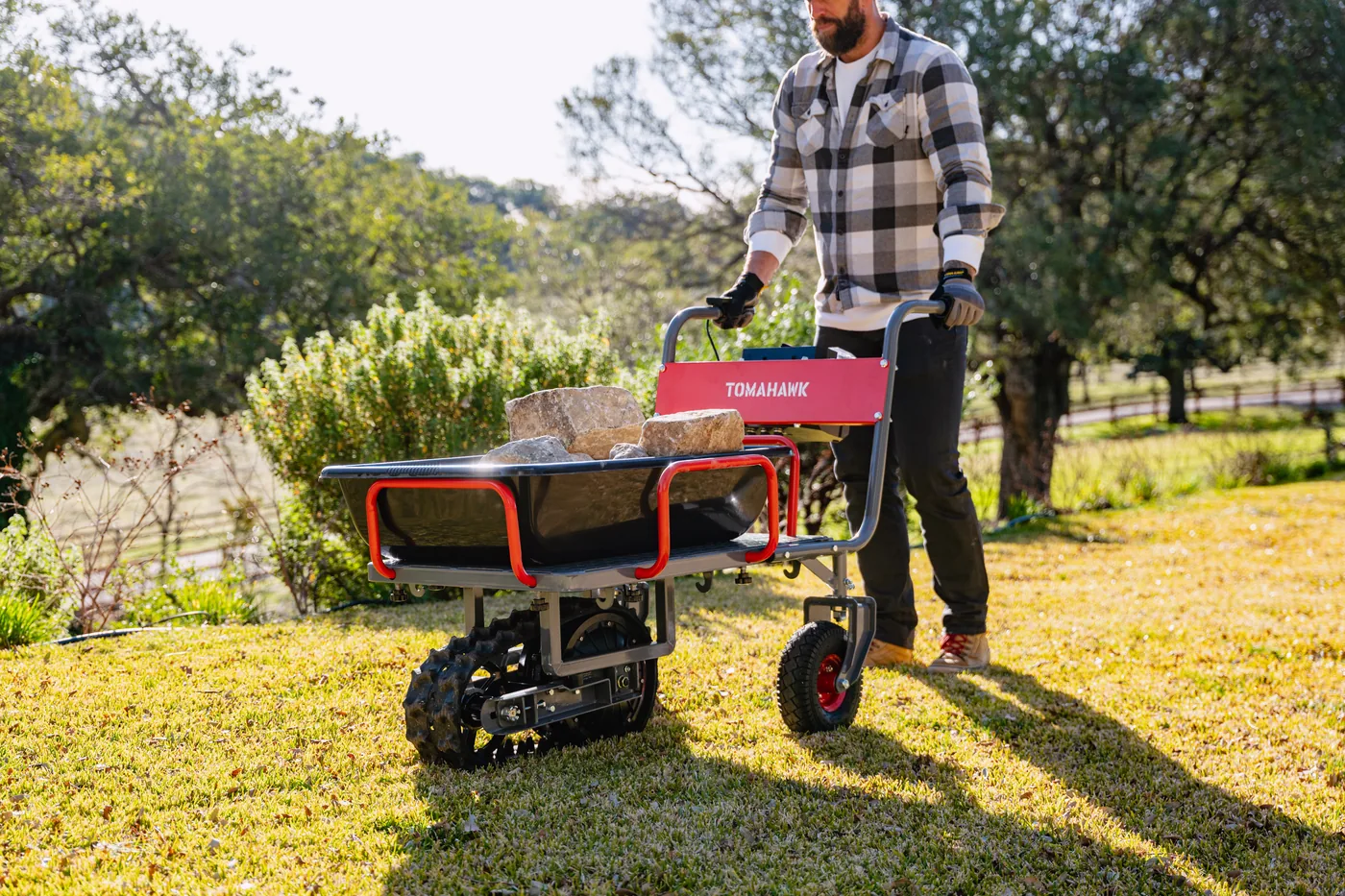 Tomahawk powered wheelbarrow loaded with soil on a shaded lawn