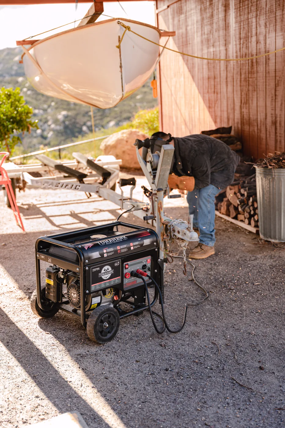 Welder generator running roadside while a welder works under a canopy