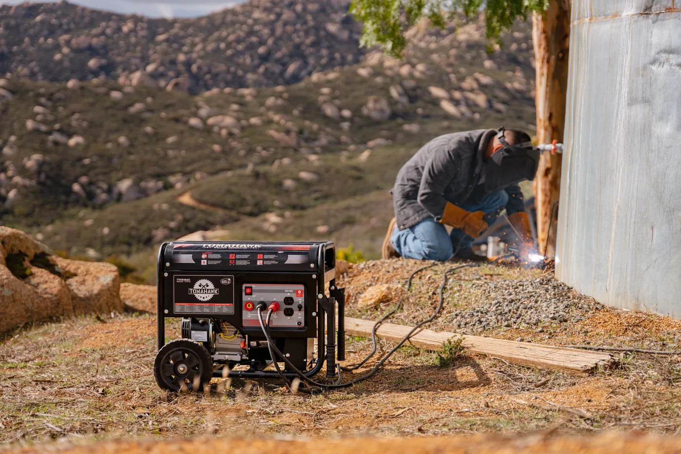 Welder generator set up on open ground below a chaparral ridge