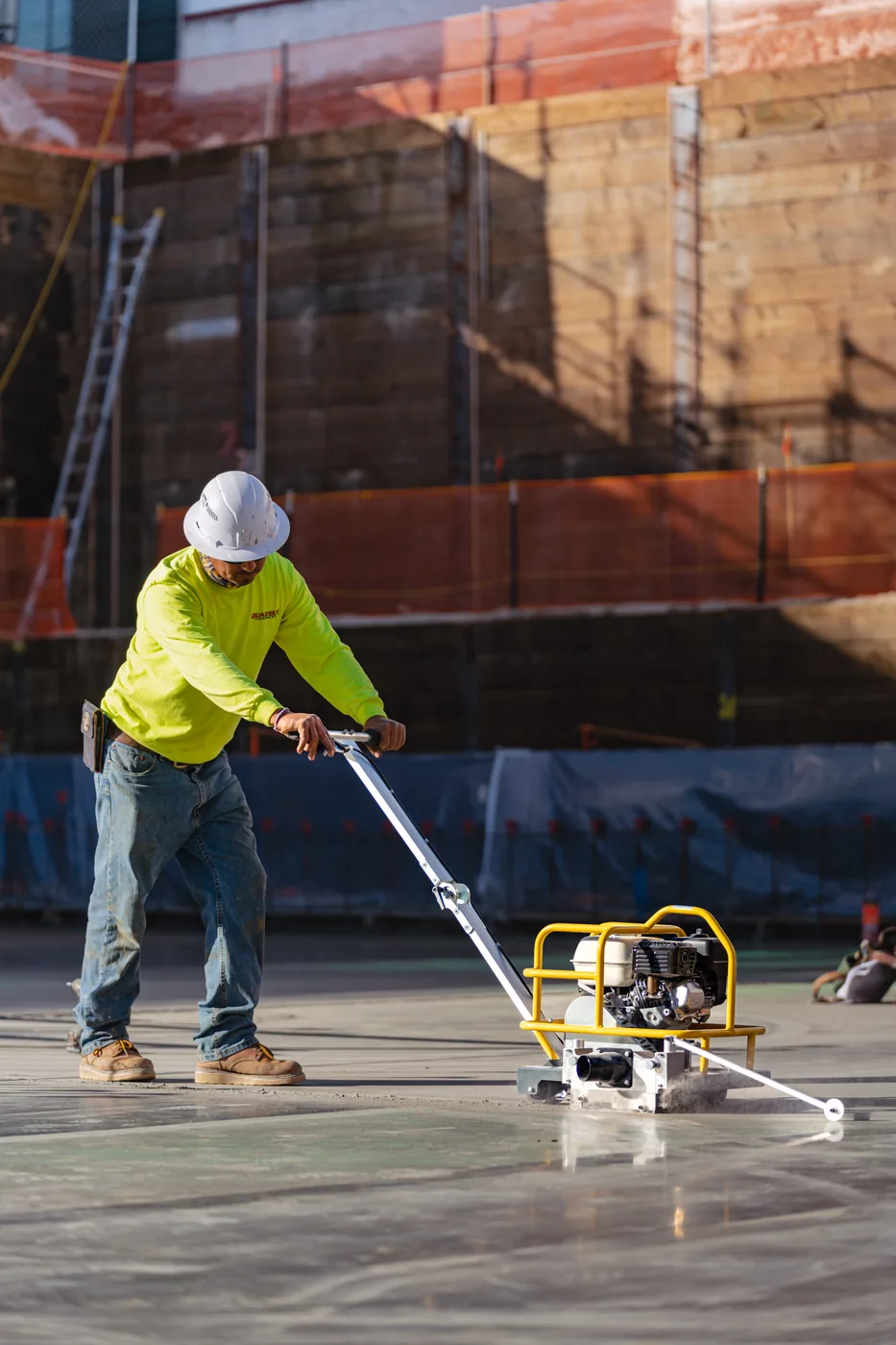 Worker cutting control joints with a Tomahawk walk-behind concrete saw